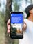 in farbiges Foto einer Person, die ein Smartphone in die Kamera hält. Darauf ist eine Instagram-Umfrage von „visitbrandenburg“ mit dem Text „Welchen Ort in Brandenburg sollen wir euch als nächstes vorstellen?“ und den Antworten „Spreewald“ und „Prenzlau“ zu sehen. Dadrunter ist ein Bild vom Spreewald und ein Bild von Prenzlau zu sehen.